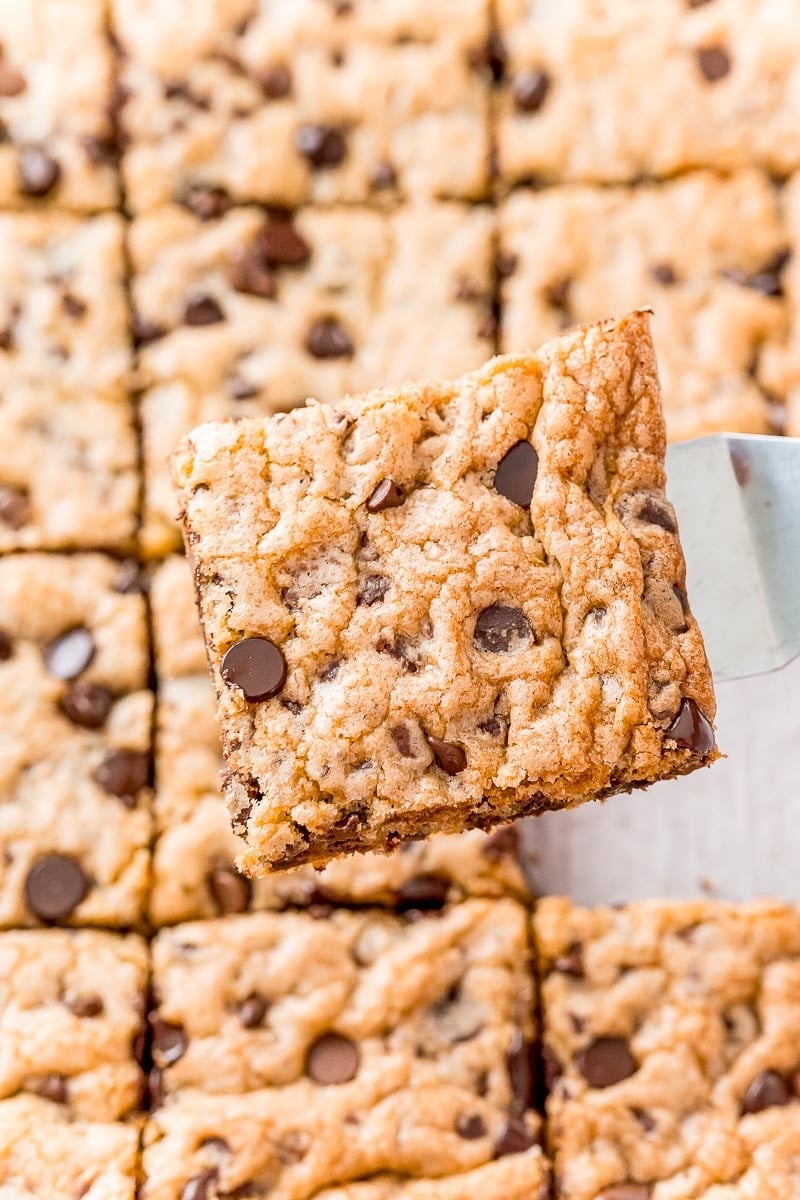 Square cookie being lifted out of a baking sheet.