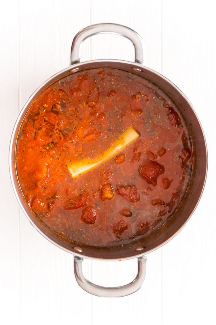 Marinara sauce in a large pot with a Parmesan rind in it.