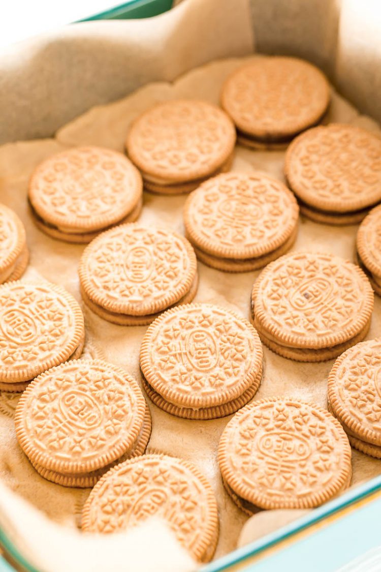 Close up photo of peanut butter pie oreos on top of cookie dough in a baking dish.