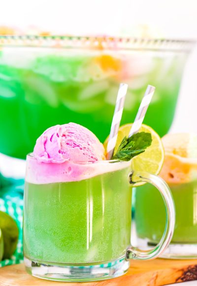 Close up photo of a clear mug filling with green punch.