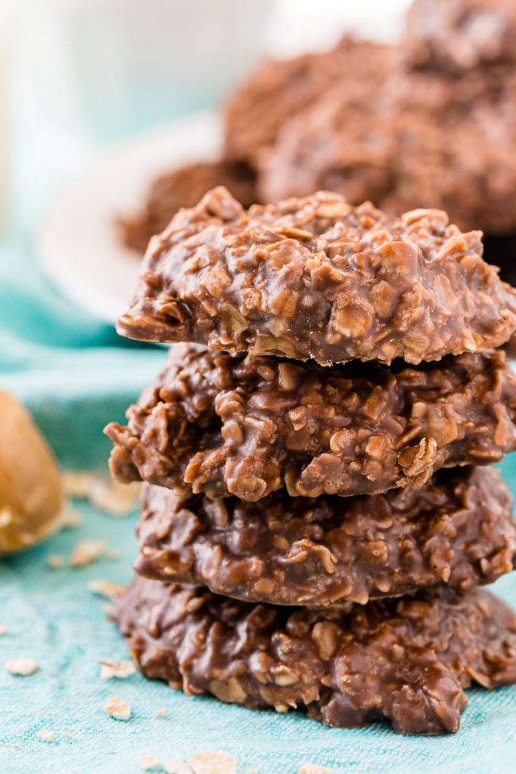 Close up photo of chocolate oatmeal no bake cookies stacked on top of each other on a blue napkin.