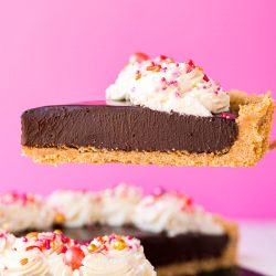 A slice of chocolate tart being lifted from the serving dish.