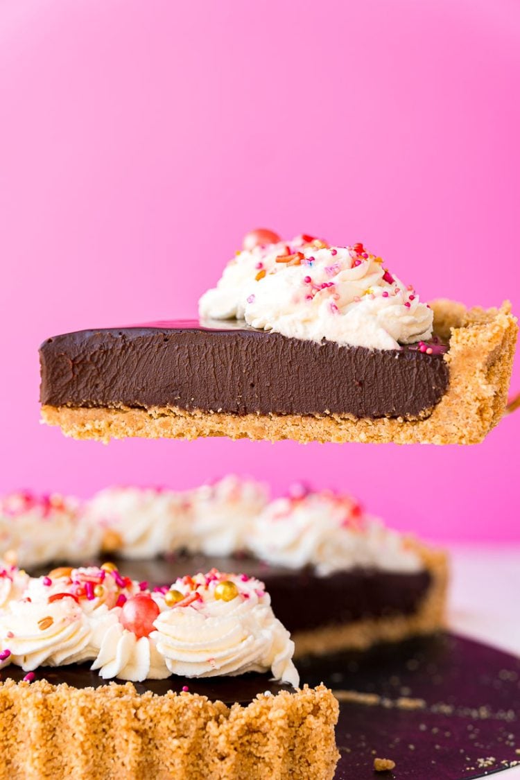 A slice of chocolate tart being lifted from the serving dish.