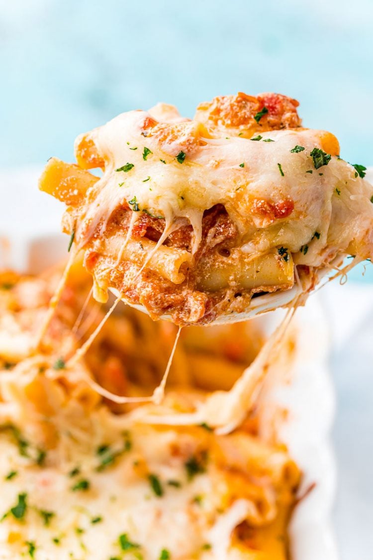 Baked Ziti being spooned out of a serving dish.