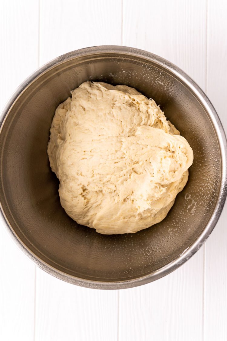 Bread dough in a large metal bowl.