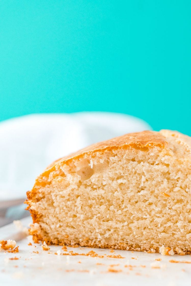 A loaf of bread that has been sliced sitting on a white cutting board.