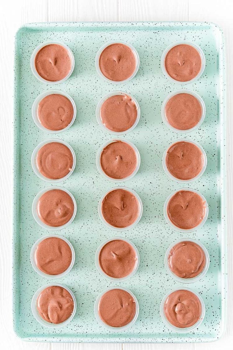 Overhead photo of pudding shots on a light blue cookie sheet.