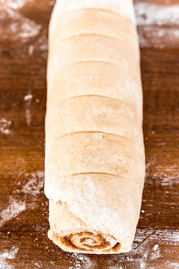 Cinnamon roll dough rolled up and ready to slice.