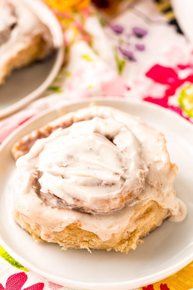 A cinnamon roll on a white plate.