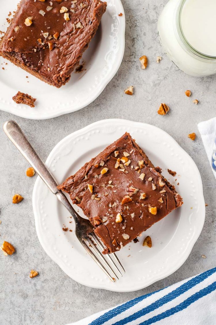 Overhead photo of slices of chocolate cake on white plates with forks.