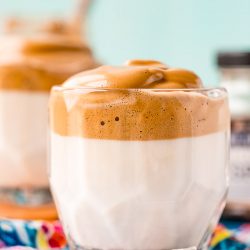 Glass of whipped coffee on a blue patterned napkin.