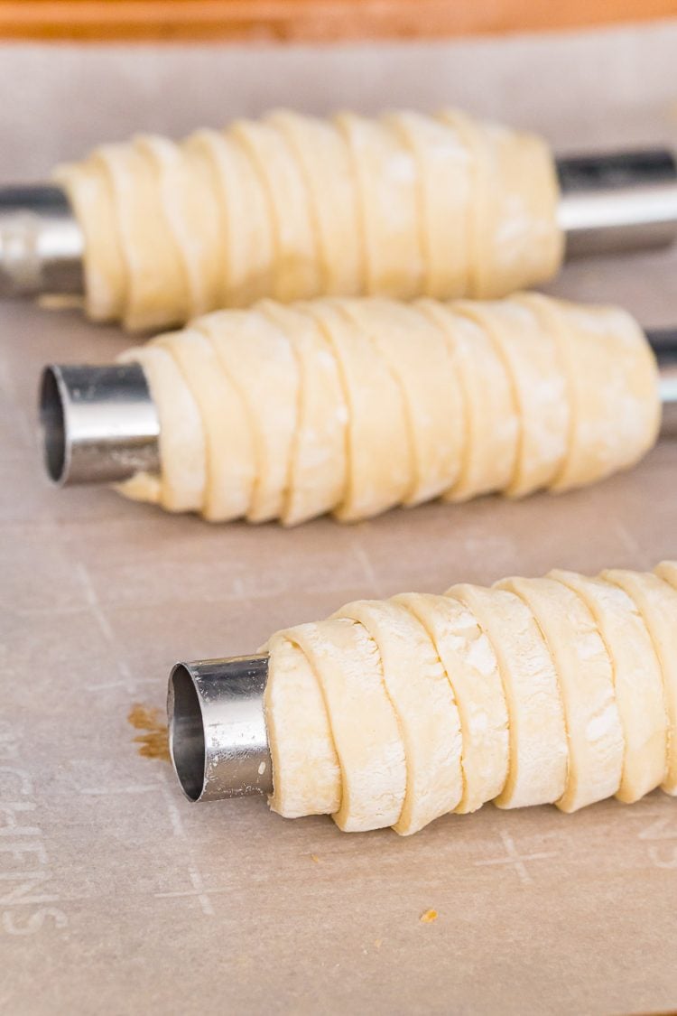 Puff pastry dough wrapped on molds to make cream horns.