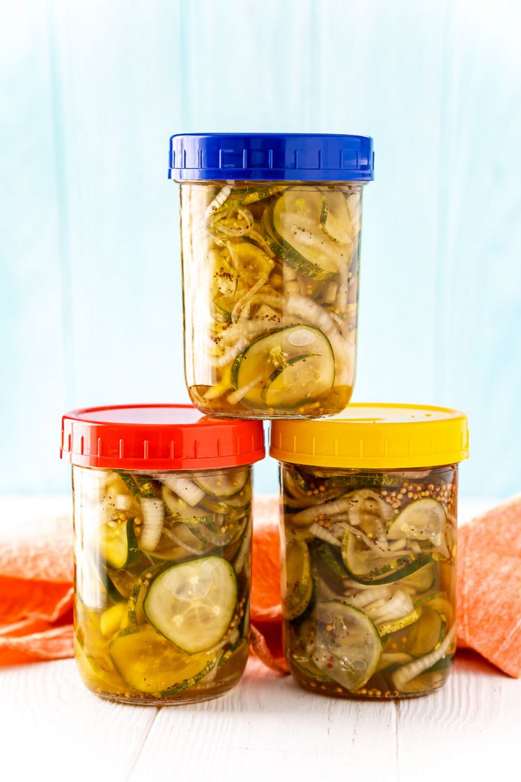 Pickles in three mason jars stacked in a pyramid.