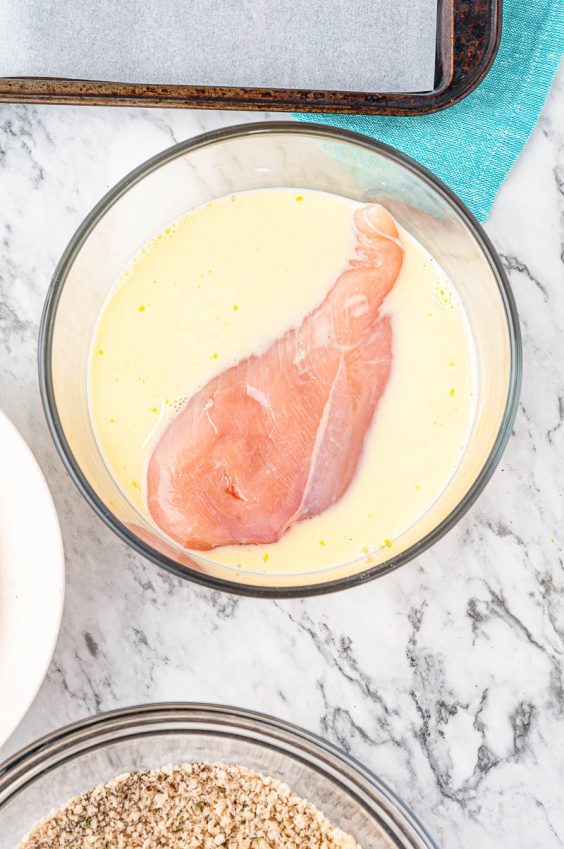 Raw Chicken Breast in liquid dip before breading