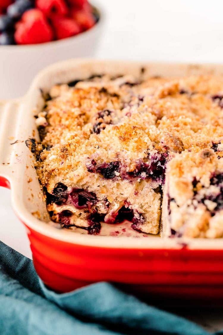 Blueberry buckle in a baking dish where one slice has been removed.