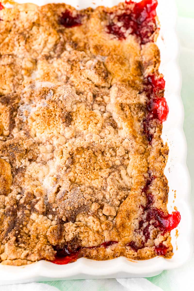 Close up photo of strawberry dump cake cobbler in a white baking dish.
