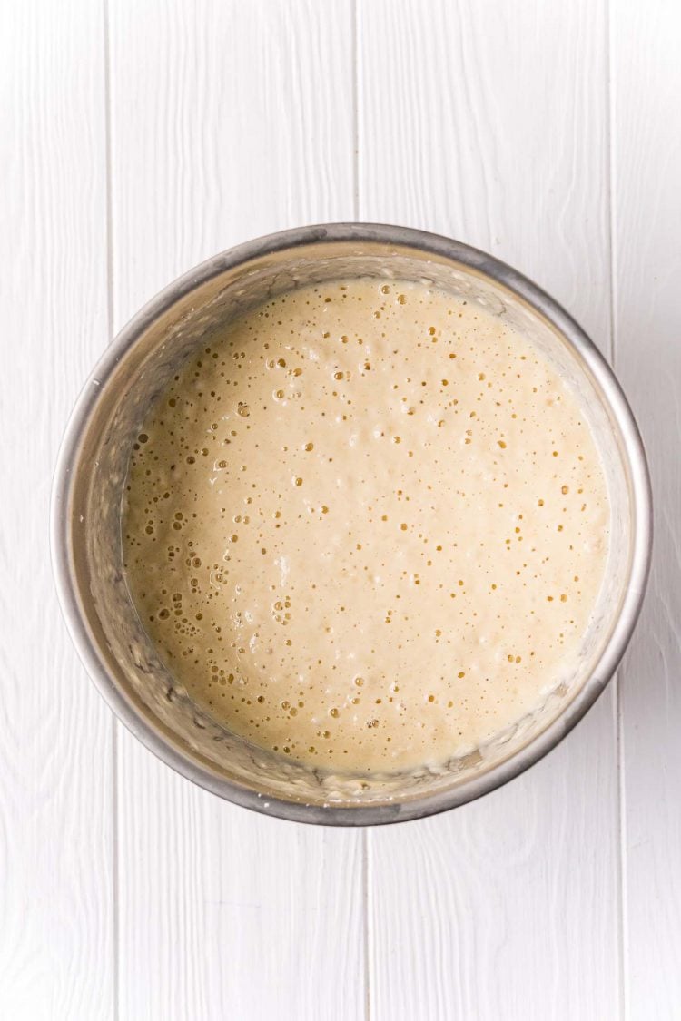 Metal bowl filling with pancake batter.