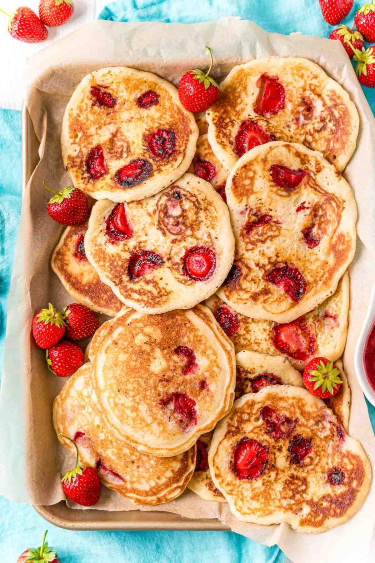 Overhead photo of a baking sheet with strawberry pancakes on it.