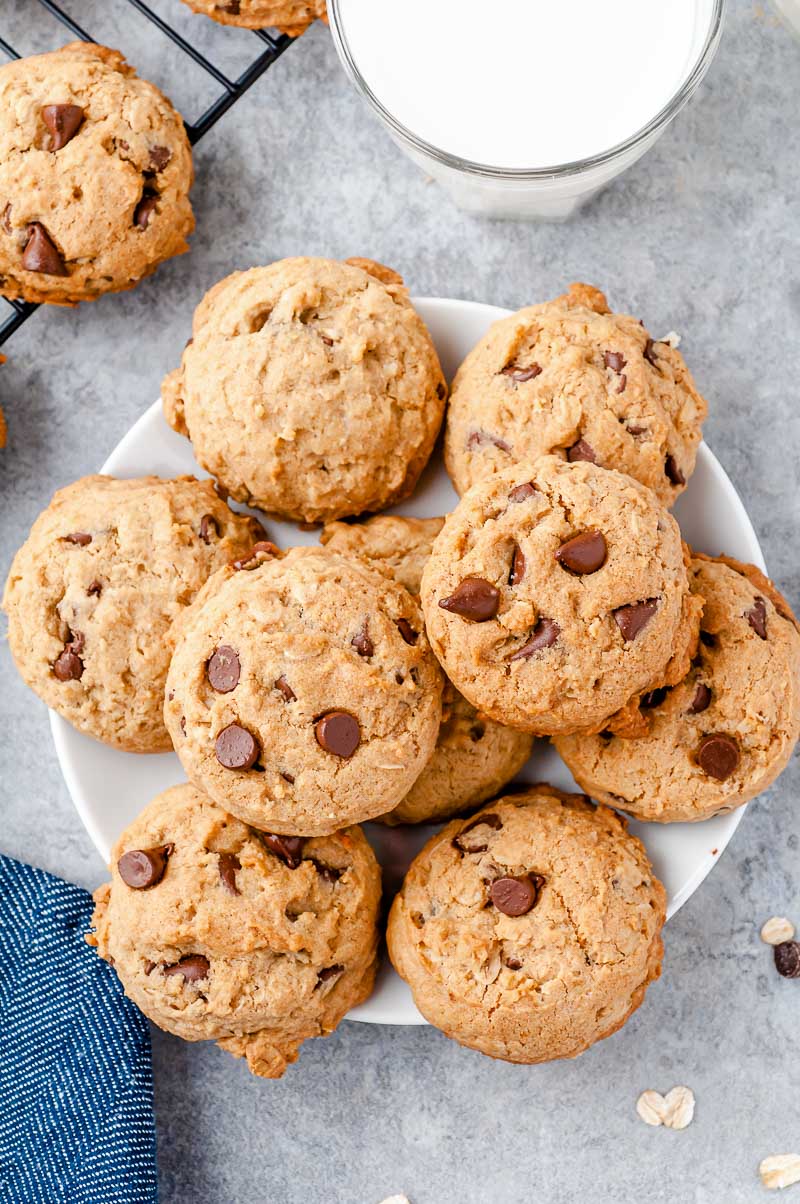 White plate filled with oatmeal chocolate chip cookies on a grey counter.