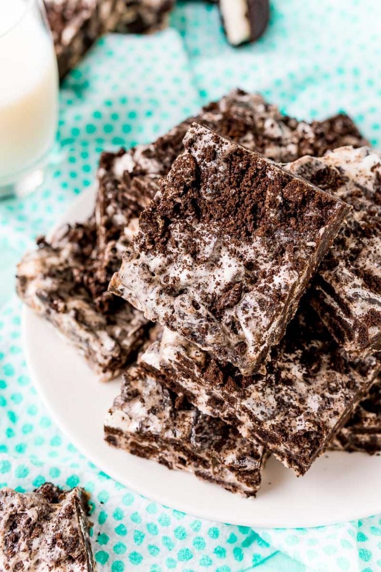 Close up photo of oreo marshmallow treats on a white plate on a blue dotted napkin.