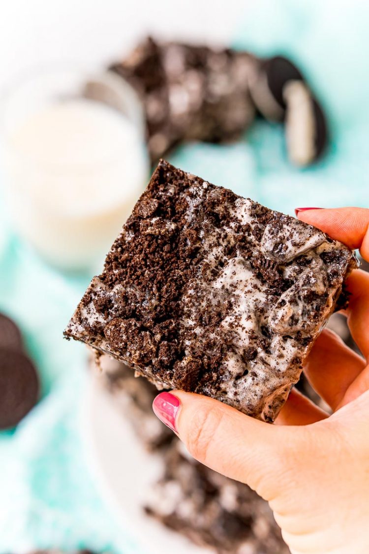 Woman's hand holding an Oreo treat square.