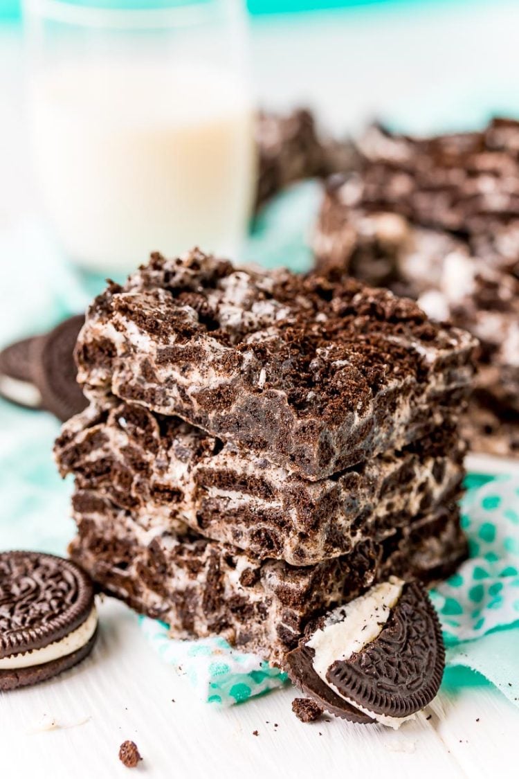 Three marshmallow oreo treats stacked on top of each other on a teal napkin.