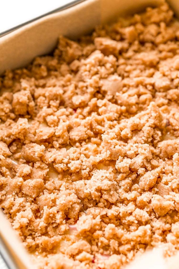 Coffee cake ready to be baked in a parchment paper lined baking pan.