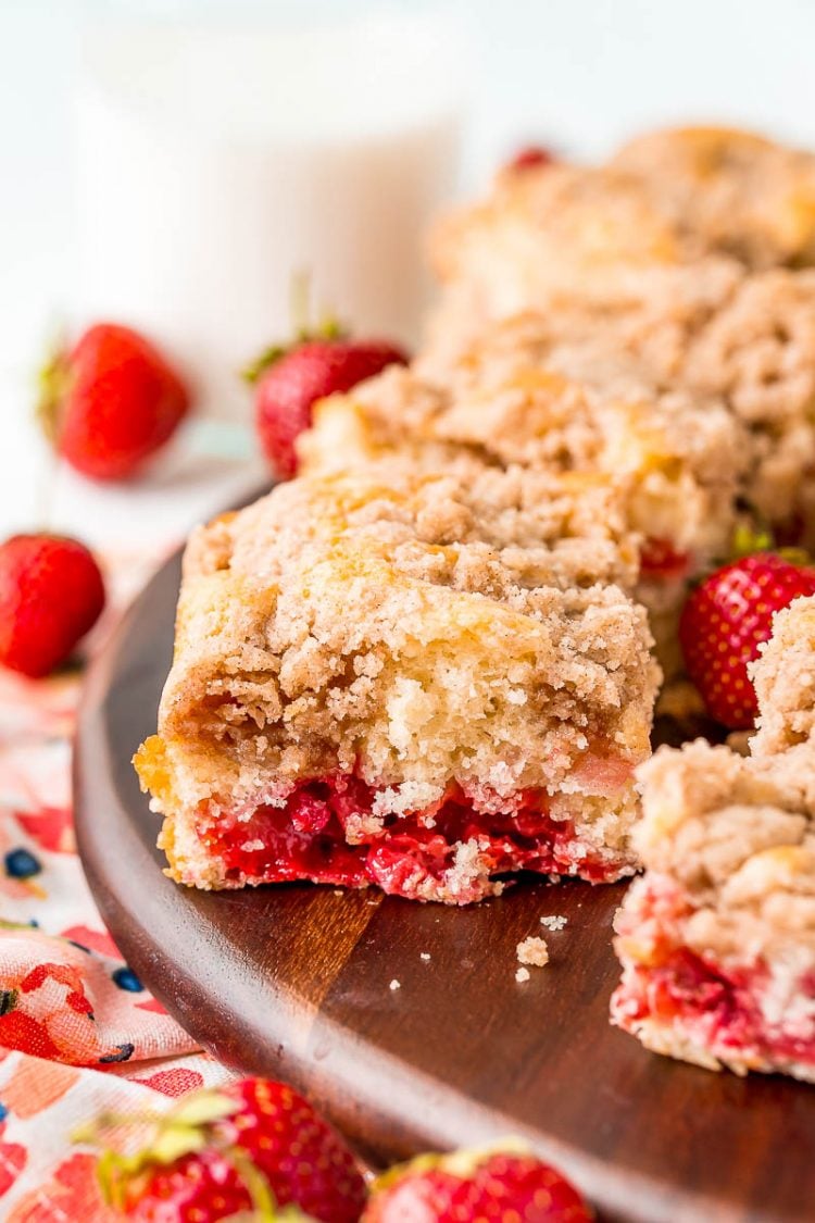 Slices of strawberry coffee cake sitting on a wooden cutting board.