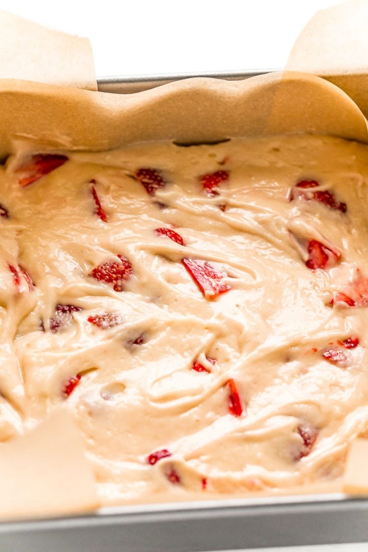 Strawberry cake in a parchment lined baking dish.
