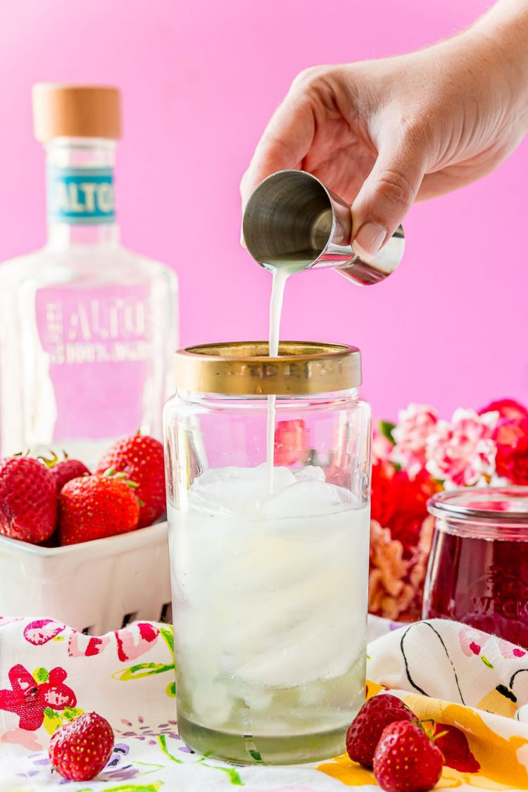 Lime juice being added to a cocktail shaker.