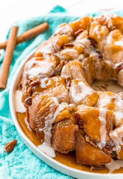 Close up photo of monkey bread on a white plate on a teal napkin.