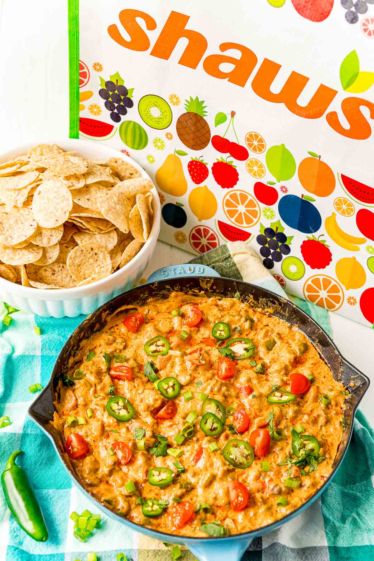 Sausage Cheese dip in a castiron pan with a bowl or tortilla chips next to it.