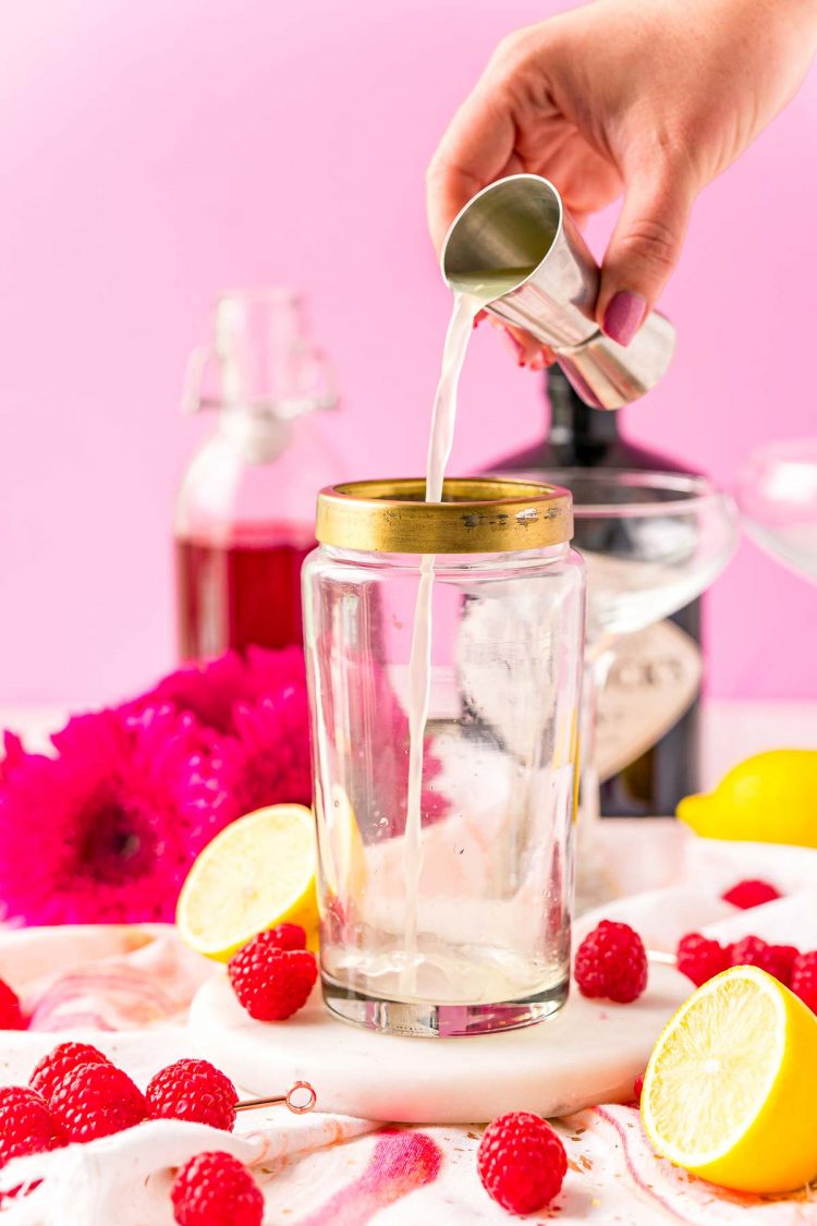 Lemon juice being added to a cocktail shaker.