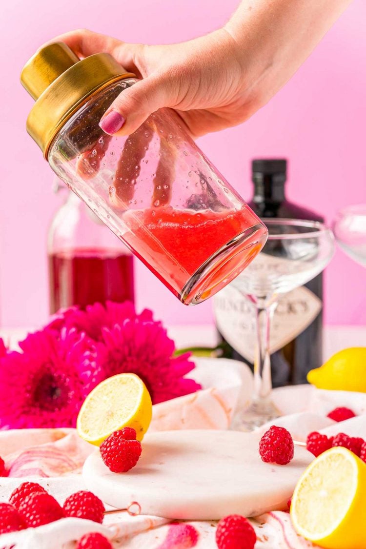 Clover club cocktail being shaken in a cocktail shaker.