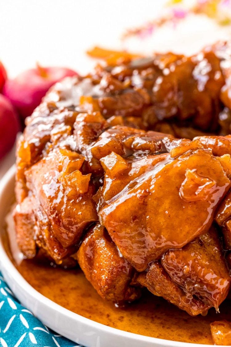 Close up photo of apple fritter monkey bread on a white plate.