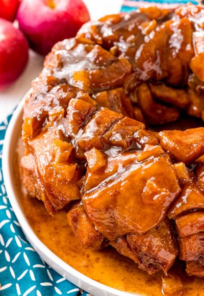 Apple monkey bread on a white plate on a blue napkin.