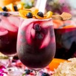 Close up photo of blueberry sangria in wine glasses and in a serving pitcher.