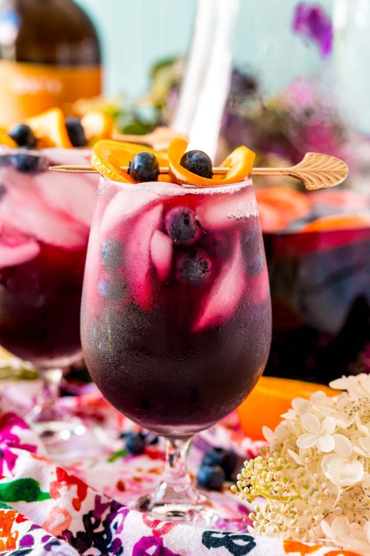 Close up photo of blueberry sangria in wine glasses and in a serving pitcher.