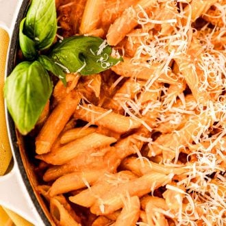 Close up photo of penne in vodka sauce in a skillet.