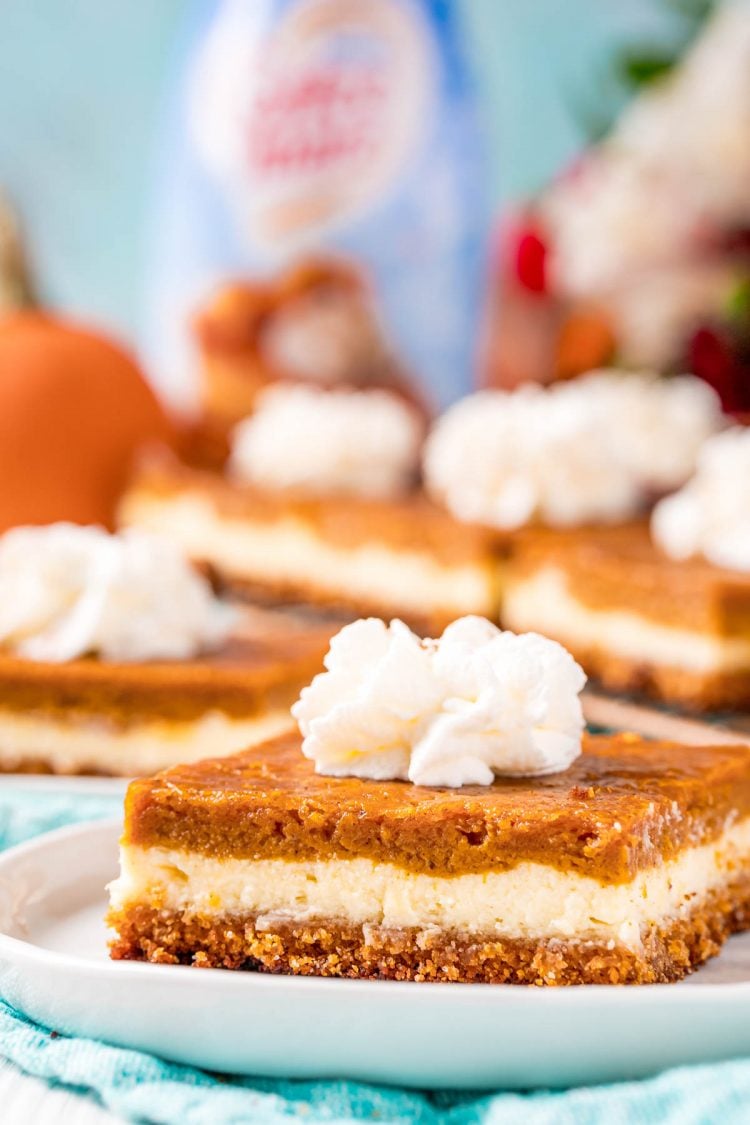 Close up photo of pumpkin cheesecake bar on a white plate.