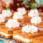 Close up photo of pumpkin pie cheesecake bars on a wire rack.