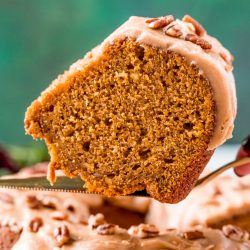 Slice of pumpkin pound cake on a serving spatula being lifted away from the cake.