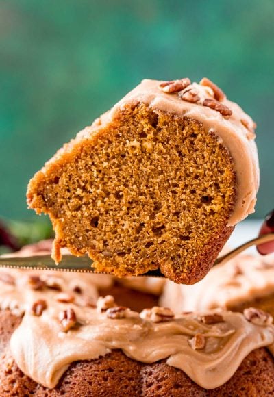 Slice of pumpkin pound cake on a serving spatula being lifted away from the cake.