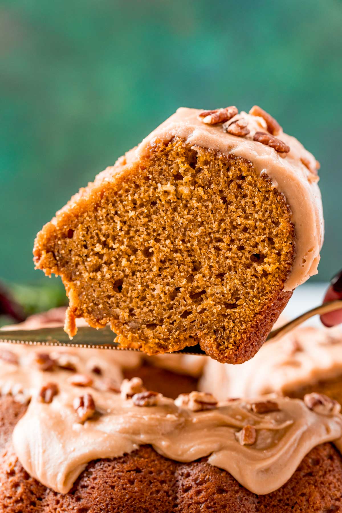 Slice of pumpkin pound cake on a serving spatula being lifted away from the cake.