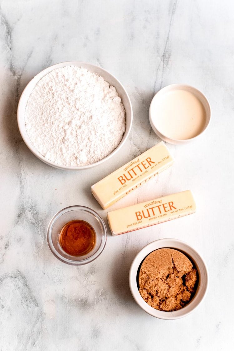 Ingredients to make brown sugar frosting on a marble surface.