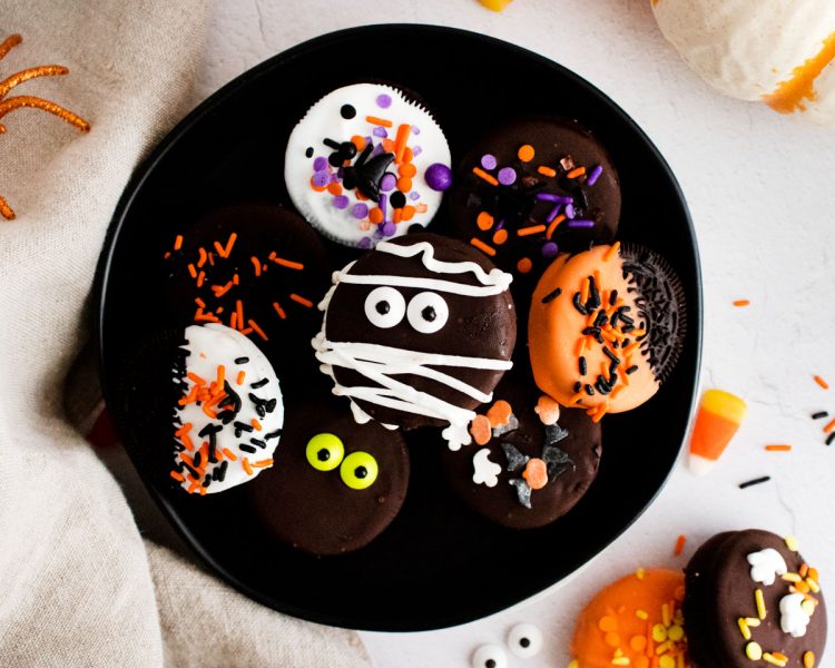 Close up photo of halloween decorate oreos on a black plate.