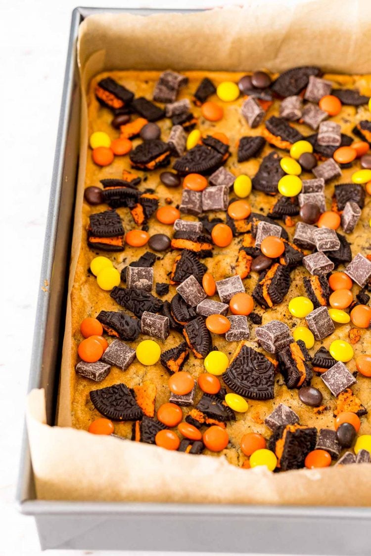 Halloween magic bars being prepared in a baking pan.