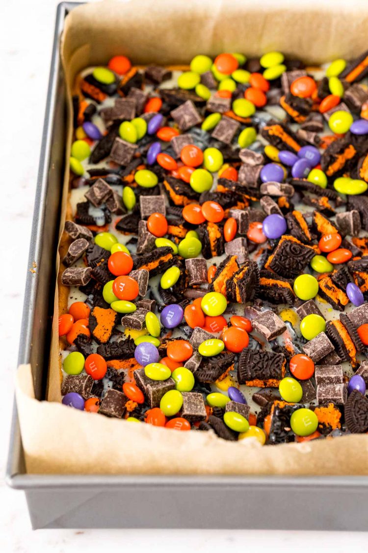 Halloween 7 layer bars being prepped in a baking pan.