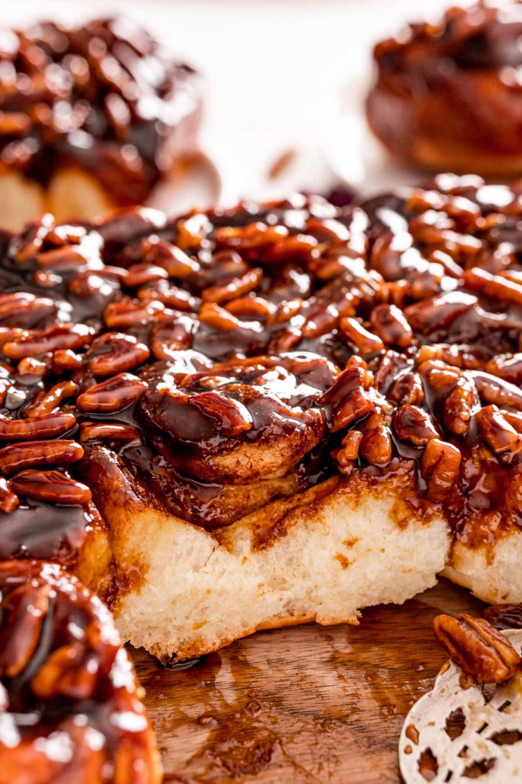 Close up photo of sticky buns fresh from the pan and one has ben taken out.