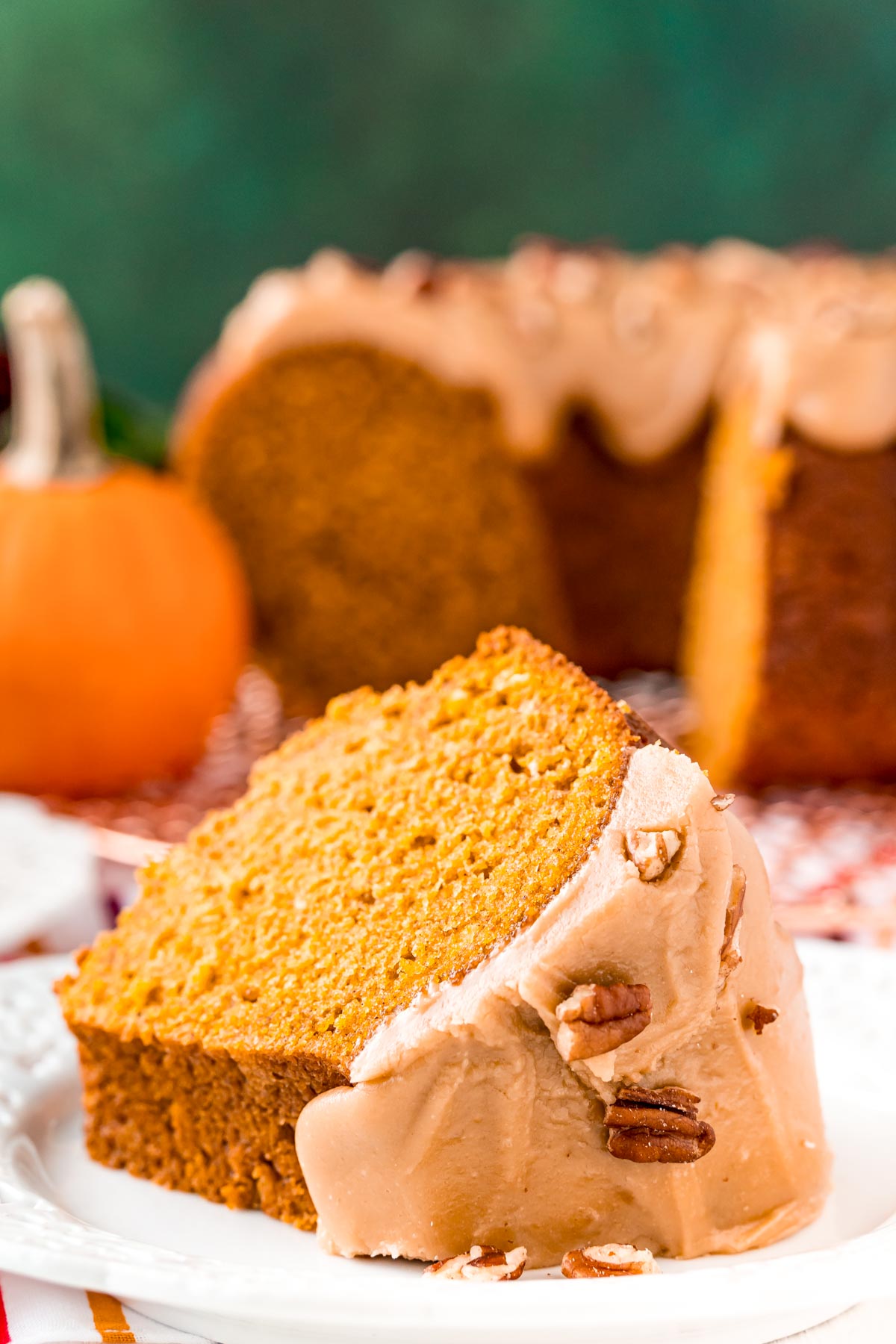 Slice of pumpkin bundt cake on a white plate.